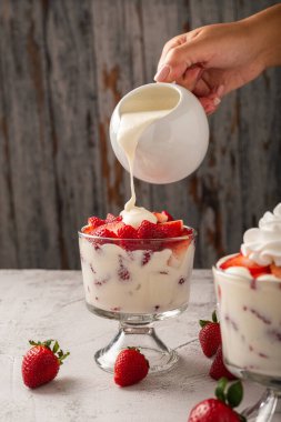 Çilekli ve kremalı cam bardağa el kremi dök. Boşluğu kopyala.