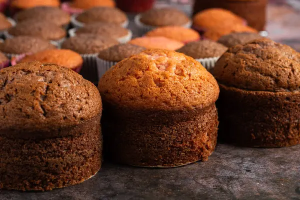 stock image Small freshly baked cake and cupcakes in the background. Pastry table.