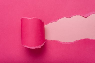 Şeftali arka planında yırtık bir delik olan pembe kağıt. Metin için boşluk.