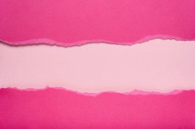Pembe arka planda koyu pembe bir kağıt yırtılmış. Metin için boşluk.