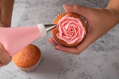 Bir keki krem peynirli kremayla süsleyen kadın elleri. Boru torbası kullanarak dekorasyon.