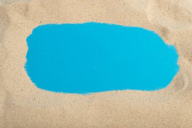 Mavi arka planda deniz kumu çerçevesi, metin için boşluk. Yaz arkaplanı.