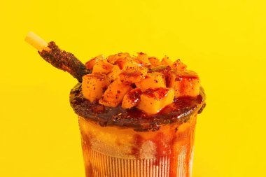 Mangonada, tipik Meksika mangolu smoothie sarı arka planda izole edilmiş..