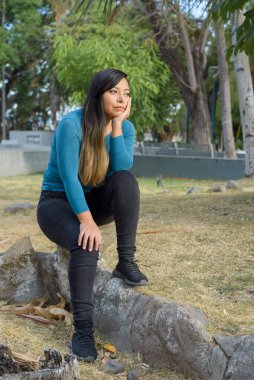 Halka açık bir parkta oturan kadın, dalgın ve düşünceli..