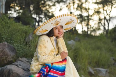 Kırsal alanda, üzerinde mariachi şapkası olan bir charro elbise giyen kız. Meksika 'nın bağımsızlık günü, Cinco de mayonez kutlaması.