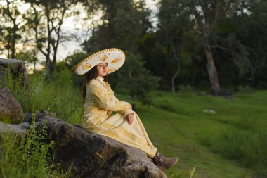 Kırsal alanda, üzerinde mariachi şapkası olan bir charro elbise giyen kız. Meksika 'nın bağımsızlık günü, Cinco de mayonez kutlaması.