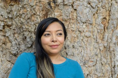 Ağaç gövdesine dayanmış bir kadının portresi..