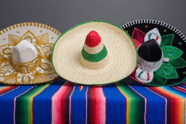 Meksika bayrağı renginde Meksika şapkaları rengarenk serapta. Gri arkaplan.