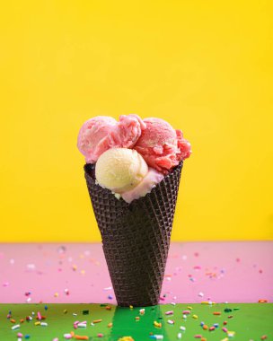 Renkli bir masada, çikolata külahında farklı lezzetlerde sanatsal dondurma..