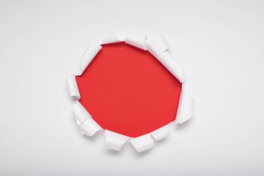 Turuncu arkaplanı gösteren yırtık beyaz bir kağıt. Metin için boşluk.