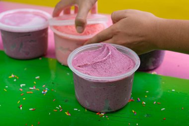 Renkli bir arka planda farklı aromalı el yapımı dondurma küvetleri..