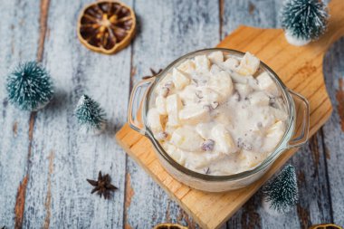 Ahşap bir masada cam bir kasede meyve salatası. Tipik Noel salatası..