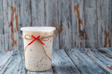 Ahşap bir masada plastik bir kabın içinde meyve salatası. Tipik Noel salatası..