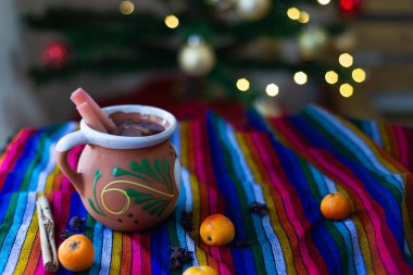 Tipik Meksika Noel yumruğu rengarenk serapta ve arka planda Noel ağacı var..