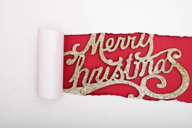 Kırmızı arka planda Mutlu Noeller tabelasını gösteren beyaz yırtık kağıt. Noel arkaplanı.