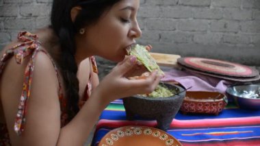 Meksikalı kadın arka bahçesinde guacamole ile tostada yiyor..