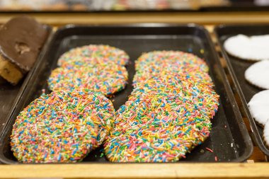 Pasta tepsisindeki çok renkli kuru üzümlü kurabiyeler..