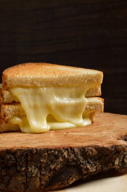 Ahşap masadaki ahşap tabakta ızgara peynirli sandviç. Boşluğu kopyala.