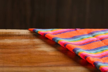 Ahşap masadaki renkli masa örtüsü. Ürün sunumu için yer. Meksika arkaplanı