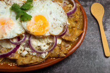 Chilaquiles, tipik Meksika yemekleri, kızarmış yumurta ve ekmekle servis edilir..