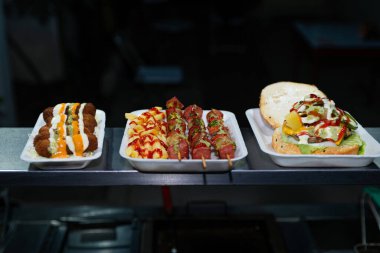 Street Food Platter Featuring Skewers, Fries, and a Burger.