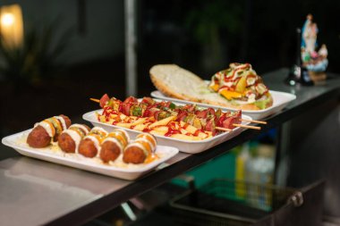 Street Food Platter Featuring Skewers, Fries, and a Burger.