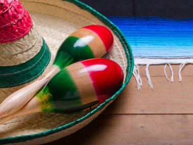 Maracas, serape ve tahta masanın üzerinde Meksika şapkası. Cinco de mayonez, boşluğu kopyala.