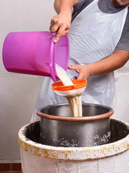 Adam antika bir el yapımı dondurma makinesine sıvı karışımı döküyor. Dondurma hazırlama süreci.