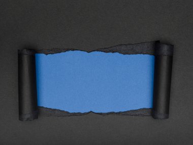 Yırtık siyah bir kağıt parçası altında parlak bir mavi bölüm ortaya çıkarıyor. Boşluğu kopyala.