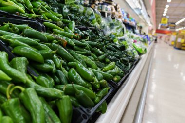 Bir süpermarket, bol miktarda taze biber ve jalapeno sosu sergiliyor..