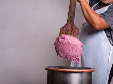 Büyük bir tahta kürek kullanan bir zanaatkar yaptığı dondurmayı sergiler..