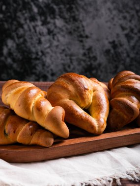 Kırsal bir ahşap tepside yeni pişmiş kruvasanların yakın plan çekimi..