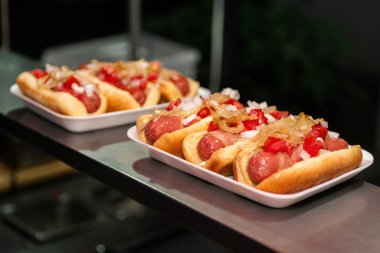 Paslanmaz çelik tezgahta sosisli sandviçler..