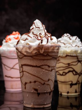 Çikolatalı milkshake, siyah arka planda berrak bir bardakta servis edilir. Ayrı bir içecek..