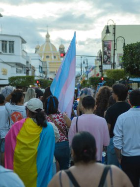 Colima, Colima. Meksika; 21 Haziran 2025: Canlı bir LGBTQ + gurur geçidi, parçalı bulutlu bir gökyüzü altında bayraklarla yürüyen çeşitli bir kalabalığı gözler önüne seriyor..