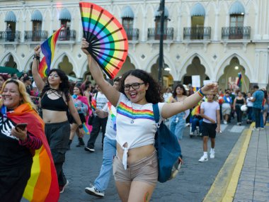 Colima, Colima. Meksika; 21 Haziran 2025: Canlı bir LGBTQ + gurur geçidi açılıyor, gökkuşağı bayrakları ve hayranları sallanan neşeli katılımcılar sergileniyor.