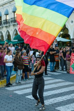 Colima, Colima. Meksika; 21 Haziran 2025: Canlı bir sokak geçidi sırasında havada dalgalanan canlı bir gökkuşağı gurur bayrağı.
