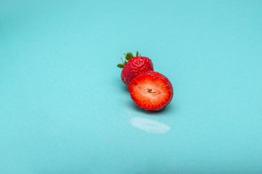 Yumuşak bir turkuaz arka planda dinlenen koca bir çilek..