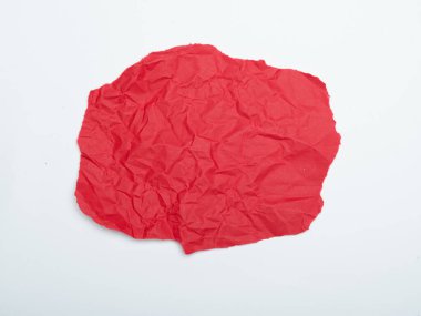 Kırmızılı, buruşmuş bir kağıt parçası beyaz bir zeminde duruyor..