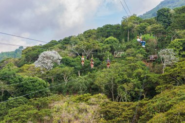 Birkaç kişi hava bisikletleriyle ve bir diğeri de yeşil bir arazide süzülen bir halatla..