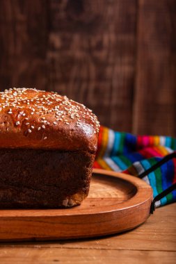 Tahta tepside susam tohumlu Salvador sarısı ekmek.