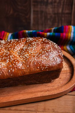 Tahta tepside susam tohumlu Salvador sarısı ekmek.