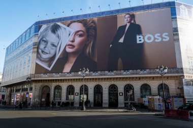 Paris, France - February 21, 2023: Giant 'Be your own Boss' advertising billboard for Hugo Boss covering the scaffoldings of the restoration work on the facade of a parisian building