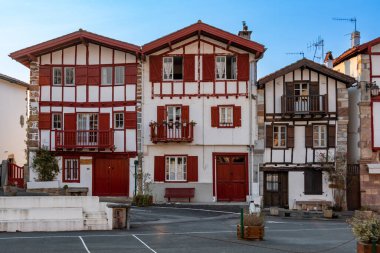 Facades of typical Basque houses in the touristic village of Ainhoa, France, commune located in the French Basque country, in the Pyrenees Atlantiques department, in the Nouvelle Aquitaine region