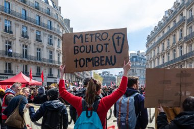 Paris, Fransa - 13 Nisan 2023: Fransız 'metro boulot tombeau' tabelası taşıyan kadın protestocu 'metro iş mezarı') Fransız emeklilik reformuna karşı bir gösteri yürüyüşü sırasında