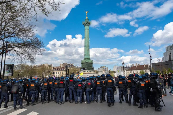 stock image Paris, France - April 13, 2023: Many French riot police (CRS) take control of the Paris' Bastille square with its famous column in the background after a protest against the retirement reform