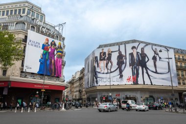 Paris, Fransa - 4 Mayıs 2023: Paris, Fransa 'da reklam kampanyaları: Galeriler Lafayette mağazasındaki Ralph Lauren reklam panosu ve H ve M binasını kapsayan Mugler dev reklam panosu