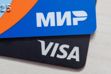 Moskova, Rusya - 28 Mayıs 2023: Visa kartının detayları ve yakın çekim Mir kartı. Visa bir Amerikan ödeme sistemidir. Mir, Rusya Federasyonu Merkez Bankası tarafından işletilen bir ödeme sistemidir.