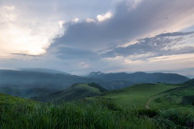 Akusha Bölgesi, Dağıstan Cumhuriyeti, Rusya Federasyonu 'nda gün batımında Kafkasya dağları ve otlakların manzarası
