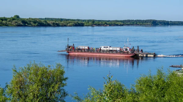 stock image Solvychegodsk, Russia - June 15, 2023: Distant view of a moving ferry, a flat-bottomed boat used to ferry people and vehicles to the opposite bank when crossing a river